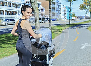 Young mother jogging with a baby buggy