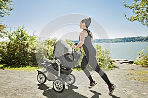 Young mother jogging with a baby buggy