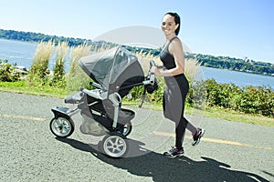 Young mother jogging with a baby buggy