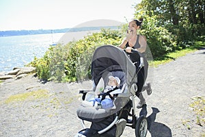 A Young mother jogging with a baby buggy