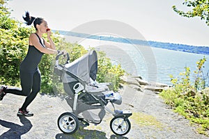 A Young mother jogging with a baby buggy