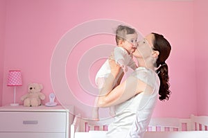 Young mother kisses her baby