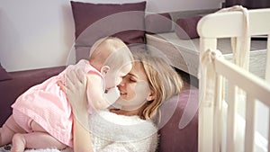 Young mother kissing baby at home. Love and happiness concept