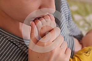 Young mother, kissing her baby boy at home. Family concept. Closeup portrait of loving mother young woman kissing little