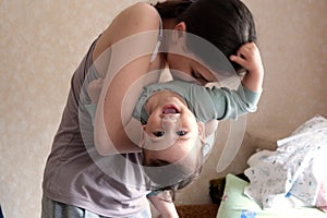 Young mother, kissing her baby boy at home. Family concept. Closeup portrait of loving mother young woman kissing little