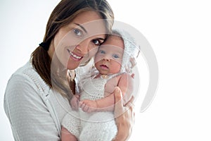 Young mother, kissing her newborn baby boy at home, mom and baby