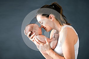 Young mother, kissing and hugging her newborn baby boy