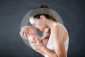 Young mother, kissing and hugging her newborn baby boy