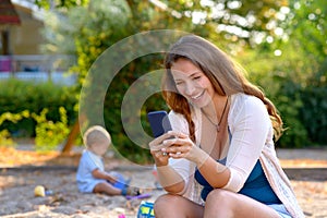 Young mother laughing at a text message