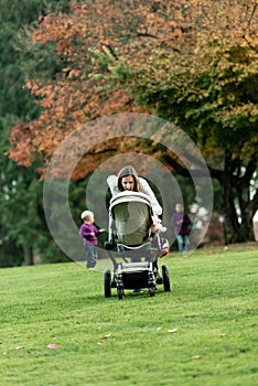 Young mother leaning over a pushchair or stroller