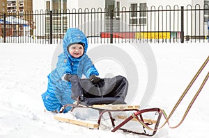 Young mother and little boy enjoying sleigh ride. Child sledding. Toddler kid riding sledge. Children play outdoors in snow. Kids