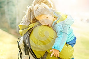 Young mother with little child doing trekking on switzerland mountain - Young people having fun in weekend day with back light -