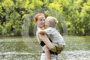 Young mother and little child kid boy son in park.Happy family playing,having fun,holding on hands,hugging in nature against trees