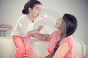 Young mother and little cute daughter playing with pinwheel