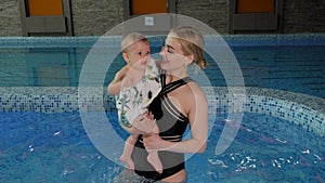 A young mother with a little daughter in the pool.