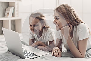 Young Mother and Little Doughter using Laptop