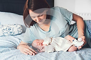 Young mother looking on her newborn baby.