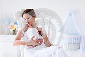 Young mother and newborn baby in white bedroom