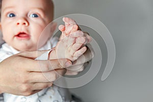 Young mother and newborn child clap their hands