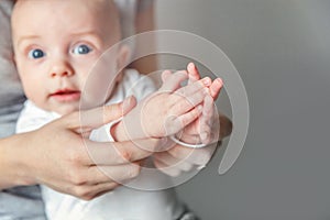 Young mother and newborn child clap their hands