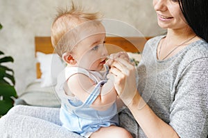 Young mother playing with her adorable baby boy at home