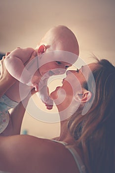 Young mother playing with her baby boy . Mother enjoying in free