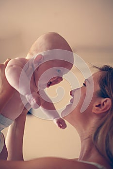 Young mother playing with her baby boy . Mother enjoying in free