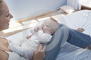 Young mother playing with her baby after feeding breast