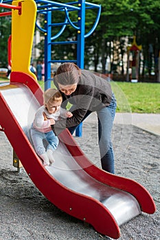 Young mother playing with her baby on the playground.