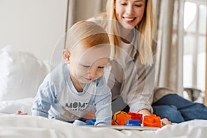 Young mother playing with her baby son at home