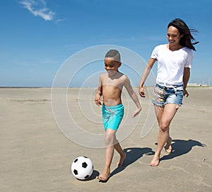 Young mother playing with son on the beach