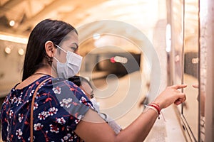 Young mother pointing and showing her daughter on the map where they are going to go. Concept of transport in the new normal with