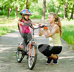 Young mother praises her daughter, who learned to ride a bike