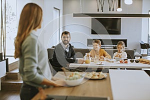 Young mother preparing breakfast for her family in the kitchen