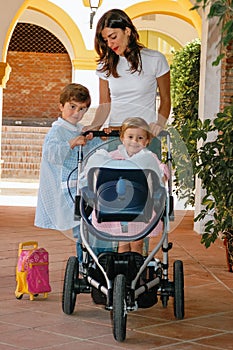 Young mother preparing and taking her children to school and kindergarten