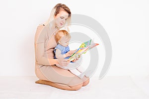 Young mother reading book for little daughter