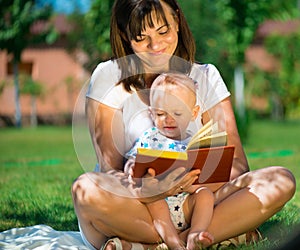 Young mother reading book to her little son