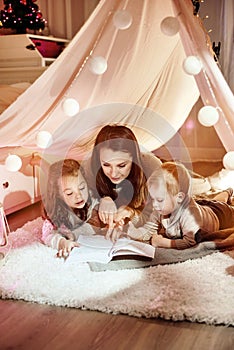 Young mother reading a novel with her kids