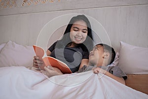 A young mother reading a storybook to her son