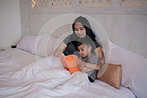 A young mother reading a storybook to her son