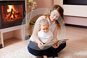 Young mother reading to her son on the floor