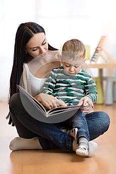 Young mother reads book to son. Cute little child boy and his mom.