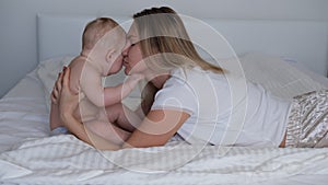 A young mother rocks the baby in her arms. The baby cries and does not want to sleep.