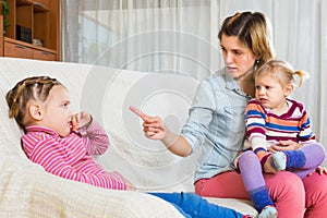 Young mother scolding little daughter