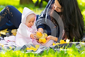 Young mother showing her baby fresh autumn apples.