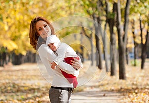 Young mother with sleeping child in autumn park