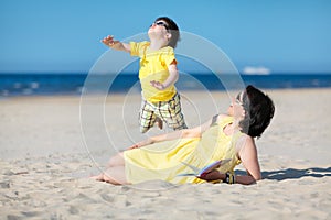 Young mother and son having fun on the beach