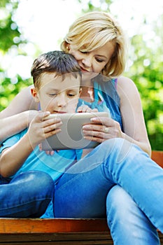 Young mother and son playing on tablet