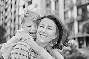 Young mother and son smiling looking at camera in modern residential complex