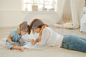 A young mother spends time with her little daughter at home. photo